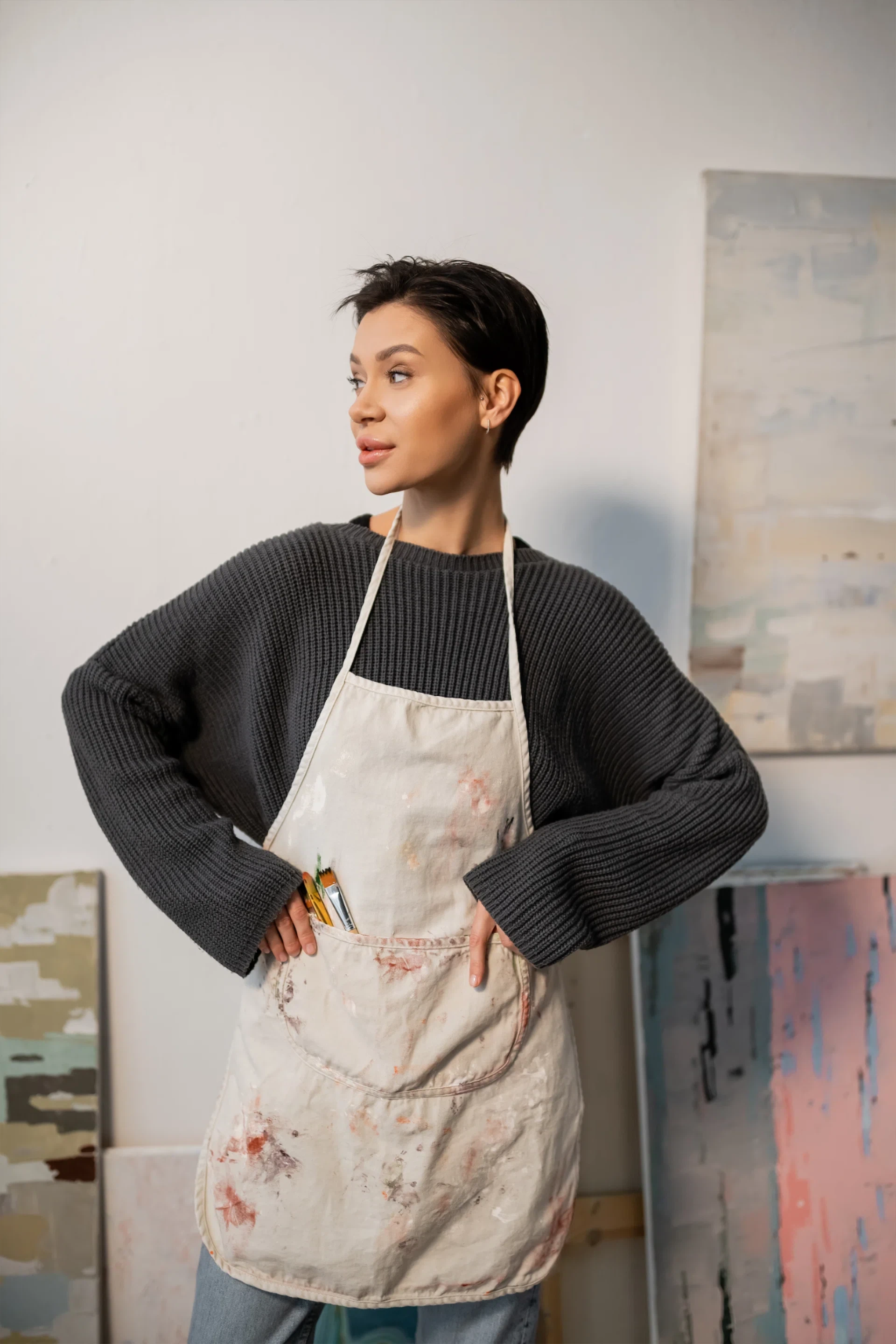 Young artist in apron with paintbrushes — Vector is a maker studio, hands-on with every project